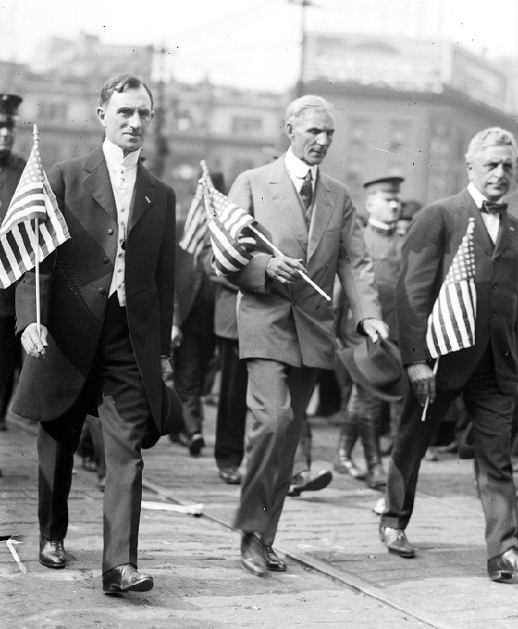 Henry Ford marches with Oscar Marx through the streets of downtown Detroit during the draft parade, circa 1914
