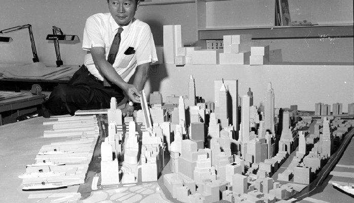 Architect Minoru Yamasaki stands behind an architectural model of New York City, 1958.